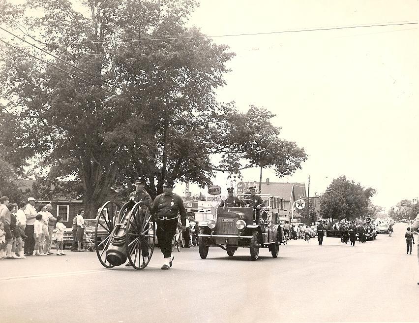 1964 - Volunteer Co. 7's chemical hose cart and 1918 Brockway.  In the distance is West Woods Co. 9 marching contingent and 1929 Seagrave aerial ladder truck.  This photo was taken on Dixwell Avenue just south of the parkway overpass near the high school.